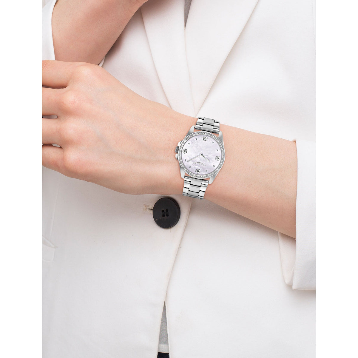 Coach Greyson women's watch worn on wrist with silver stainless steel case and mother-of-pearl dial