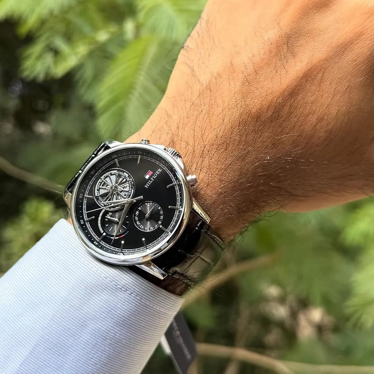 Tommy Hilfiger Stewart watch on wrist outdoors showing black dial and chronograph dial layout