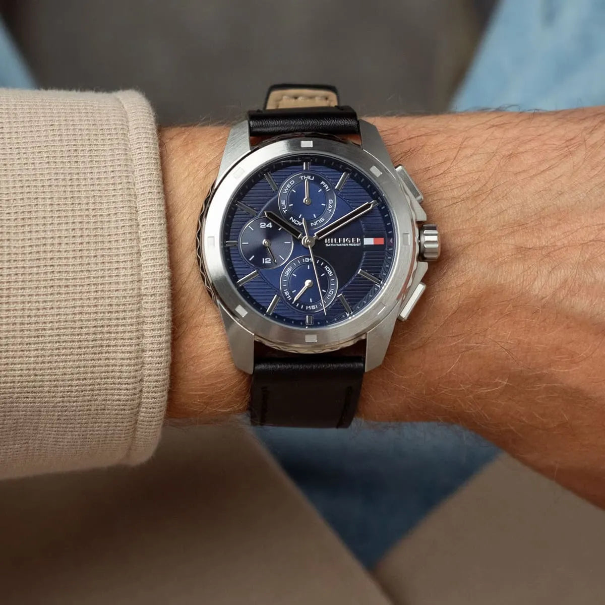 Tommy Hilfiger chronograph watch worn on wrist showing navy dial and black leather band