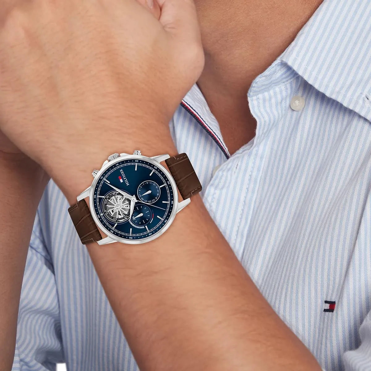 Tommy Hilfiger Stewart men's watch on wrist with brown leather strap and navy dial