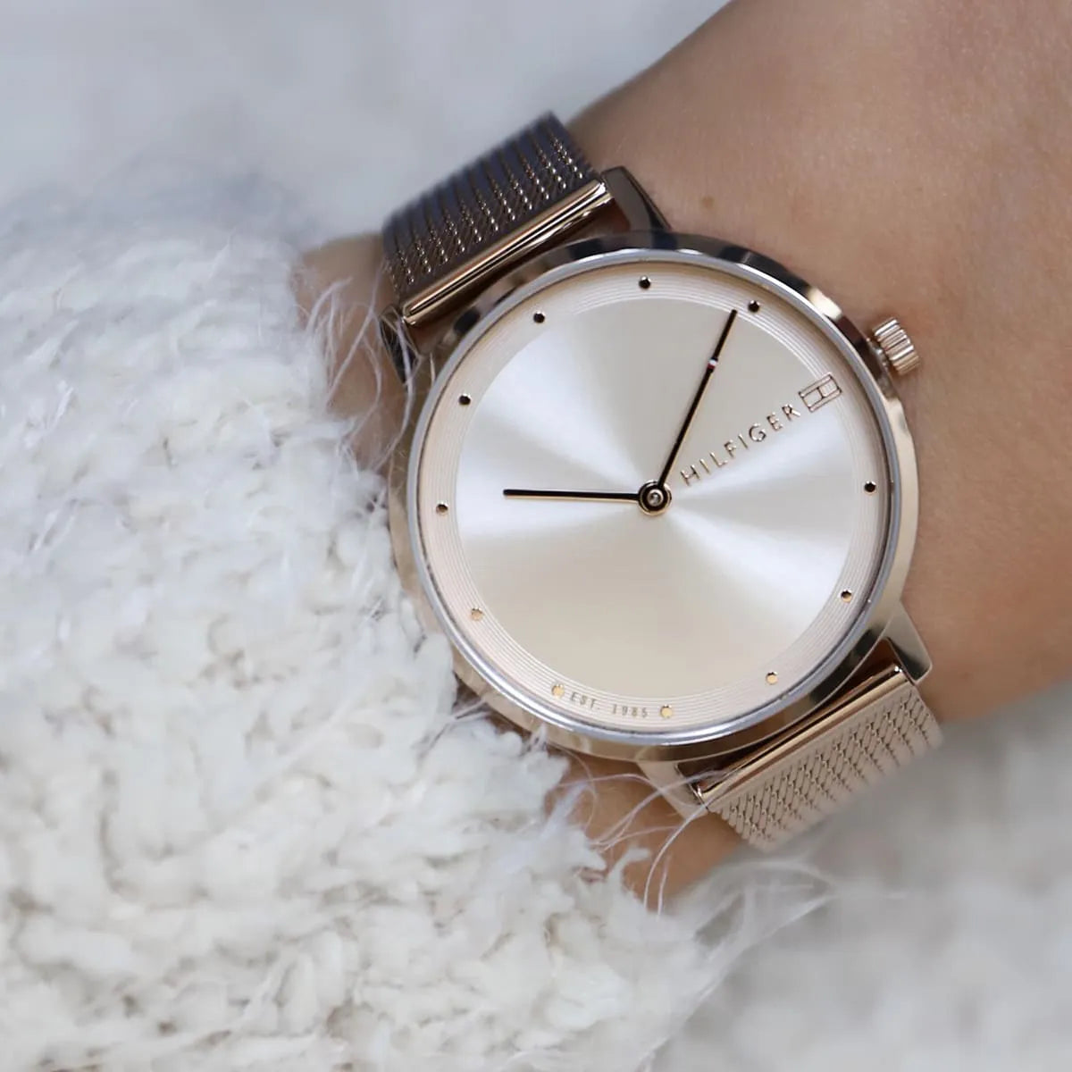 Tommy Hilfiger slim watch on female wrist with rose gold dial visible