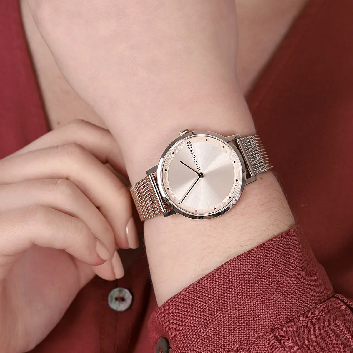 Tommy Hilfiger Pippa watch worn on woman's wrist with burgundy sleeve