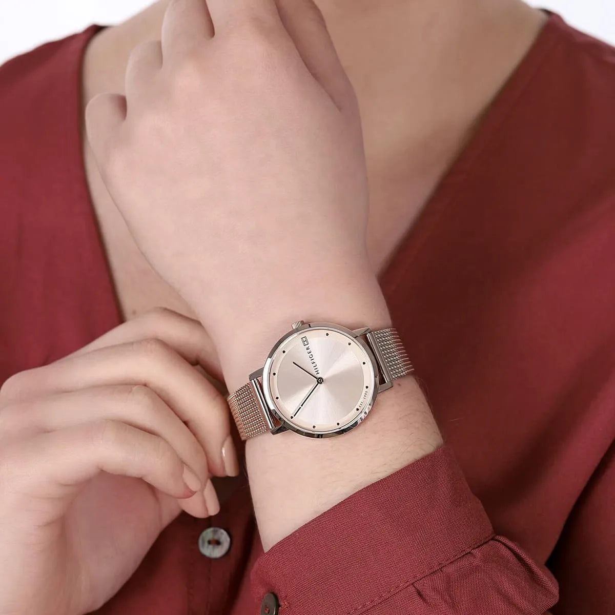 Woman wearing Tommy Hilfiger mesh watch with burgundy top