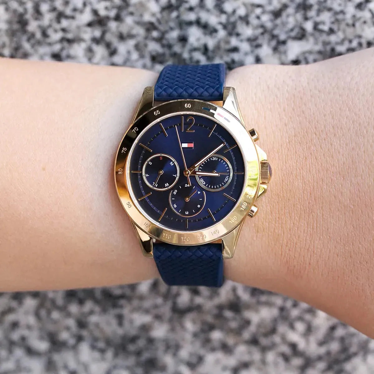 Tommy Hilfiger Haven chronograph watch worn on wrist with blue strap and gold case