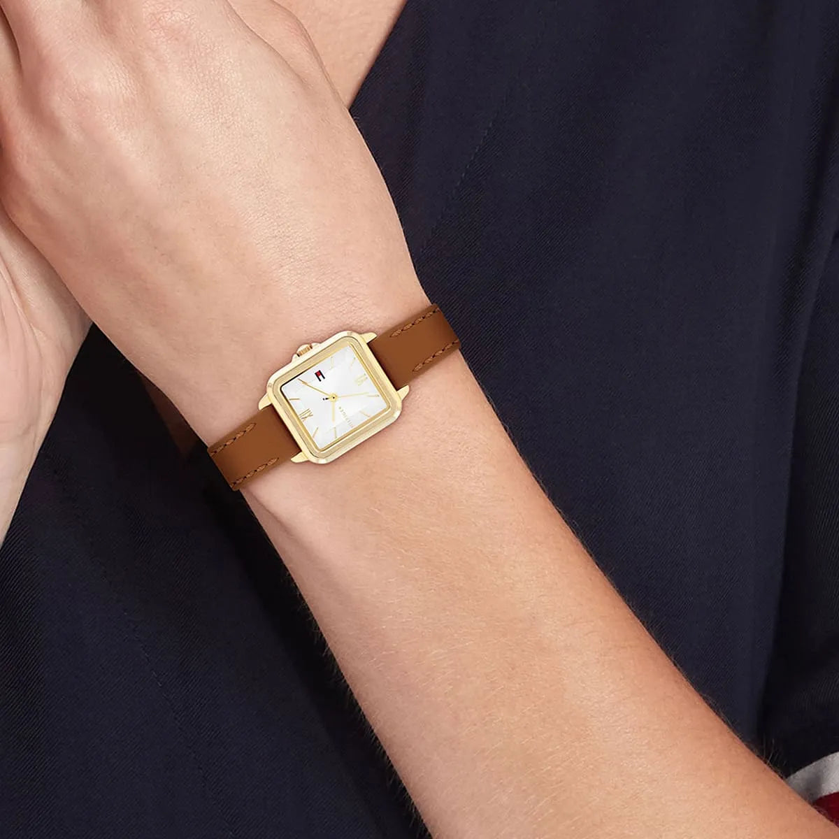 Tommy Hilfiger Mia watch worn on wrist showing square gold case and white dial
