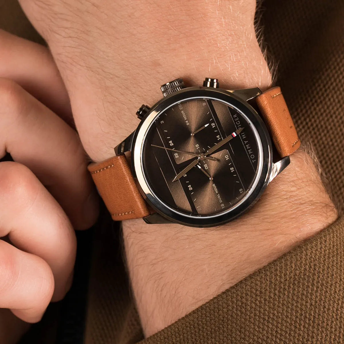 Close-up of Tommy Hilfiger dual time brown dial watch worn on wrist