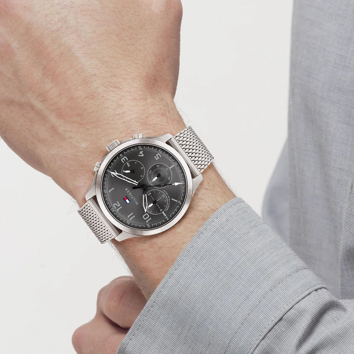 Tommy Hilfiger Asher watch on wrist with grey dial and silver mesh strap