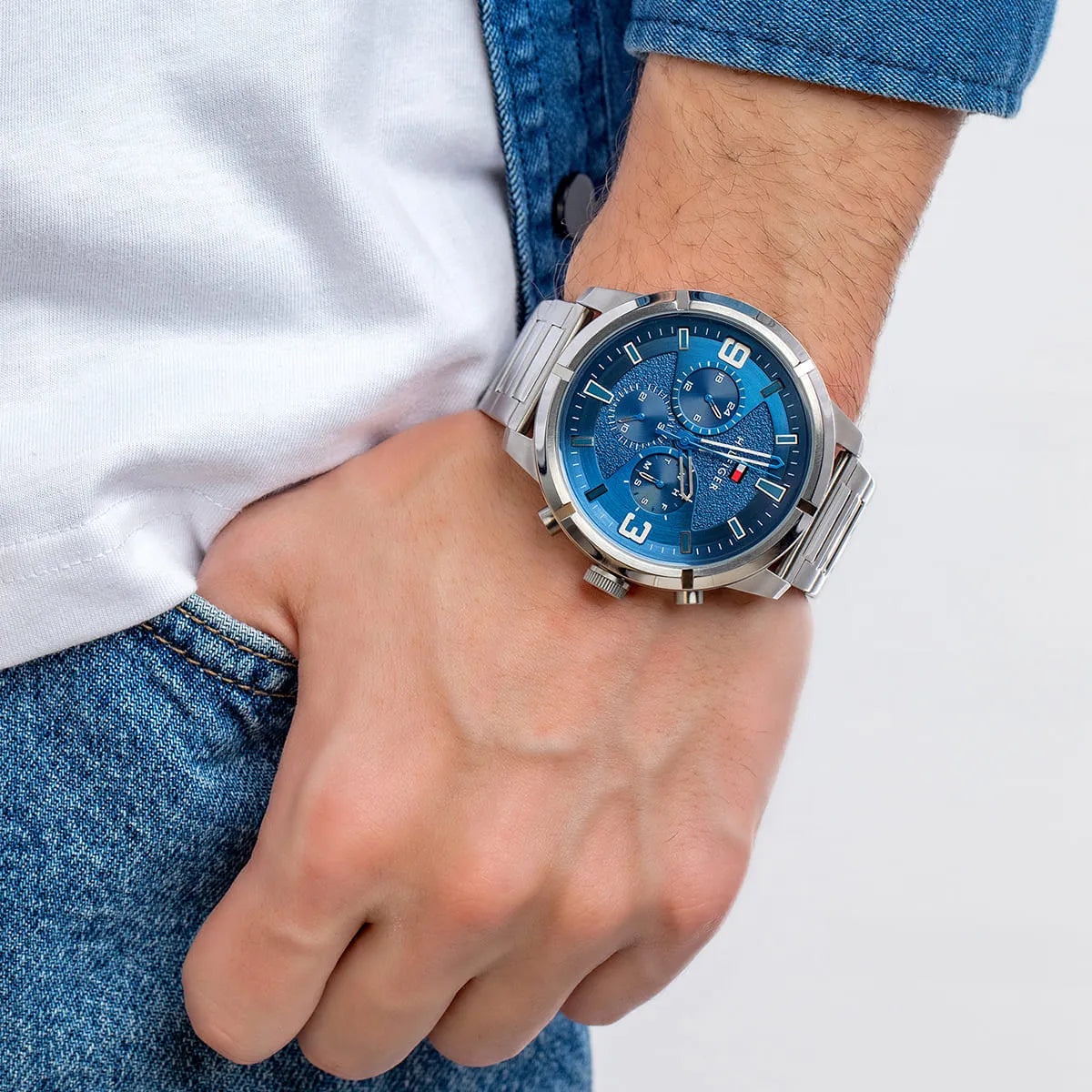 Tommy Hilfiger men's watch worn on wrist with blue dial and silver metal strap