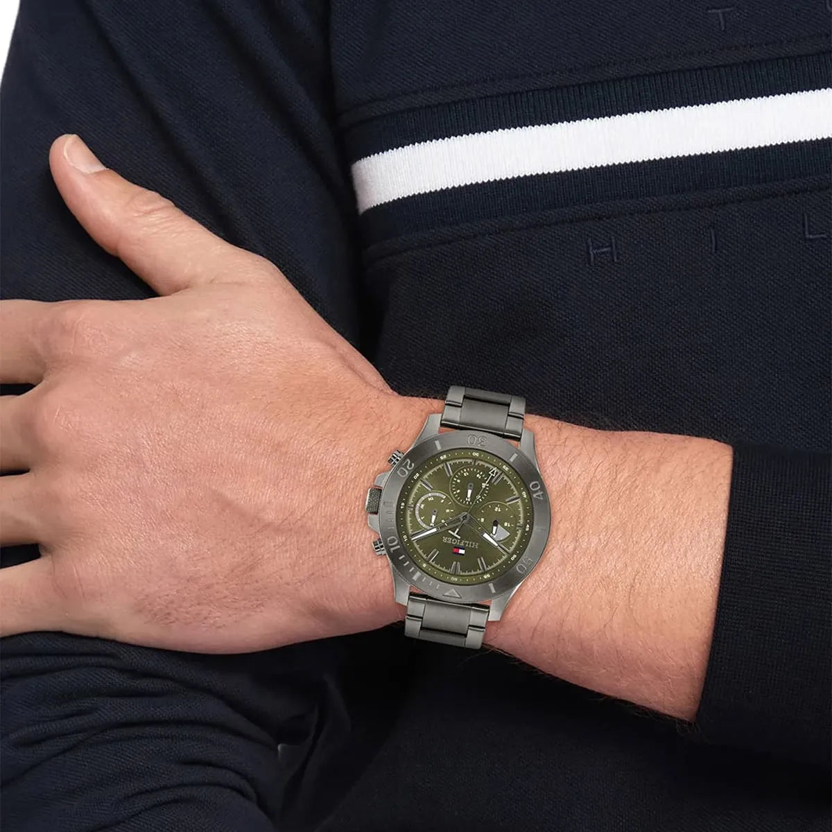 Tommy Hilfiger green dial chronograph watch worn on wrist with grey stainless steel bracelet