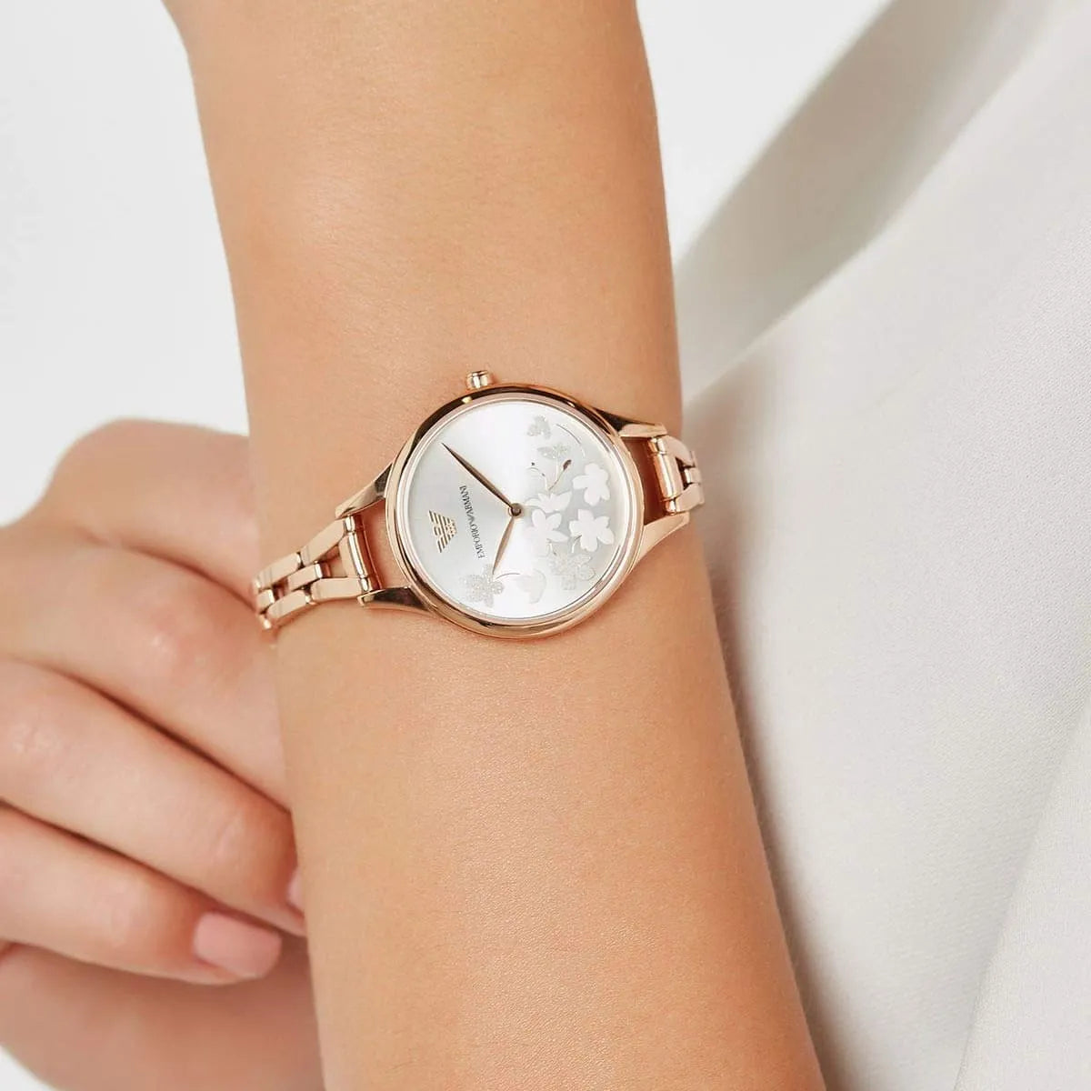Emporio Armani Aurora watch on wrist showing silver dial with floral design and rose gold bracelet