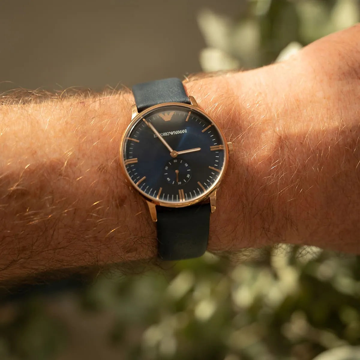 Emporio Armani AR2071 on wrist showing blue dial, rose gold case, and blue leather strap