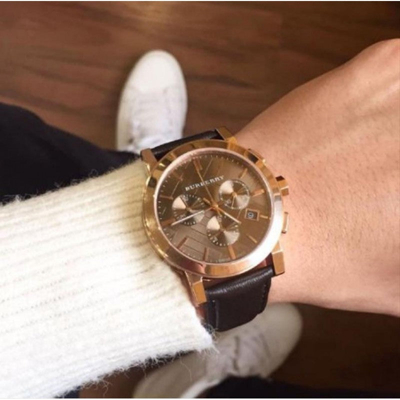 Burberry The City watch worn on wrist with rose gold case and chocolate brown strap