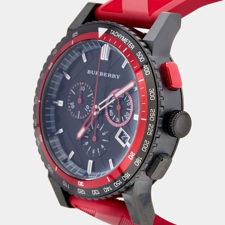 Burberry The City chronograph worn on wrist with red rubber strap visible, black case and bezel