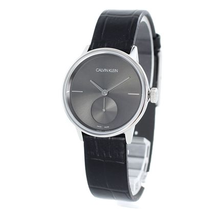 Calvin Klein Accent watch at angle showing silver case, black dial, and leather strap
