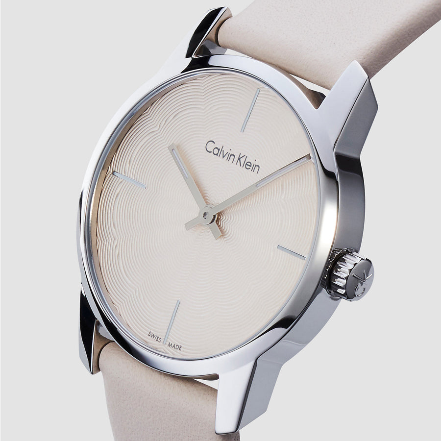 Calvin Klein City watch side view showing silver case and beige leather strap on wrist