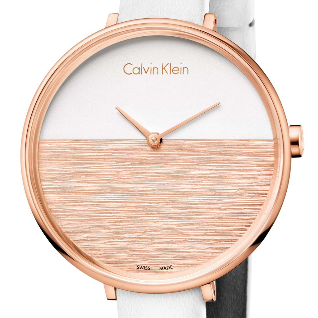 Calvin Klein K7A236LH watch dial detail showing split white and wood texture design with rose gold hands