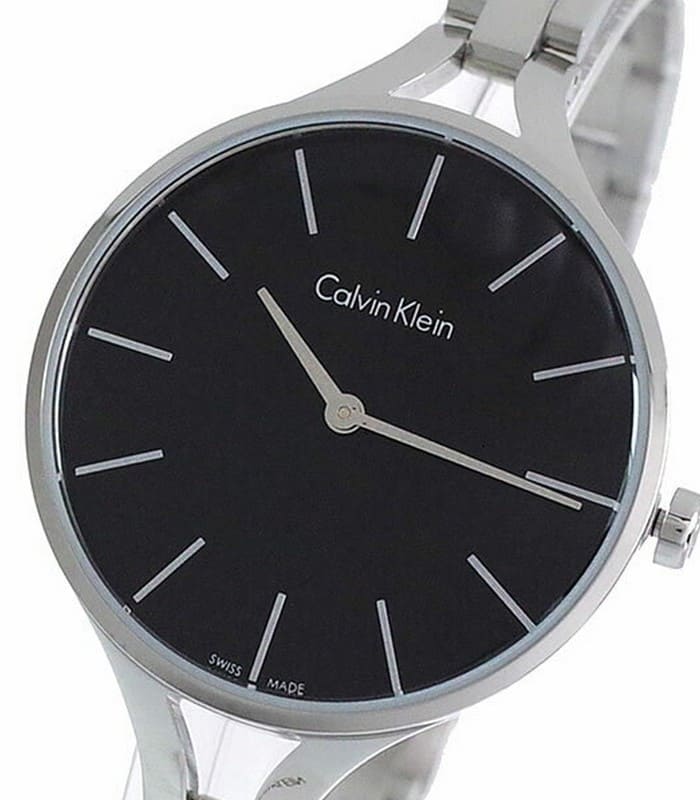 Close-up of black dial with Calvin Klein branding and hour markers