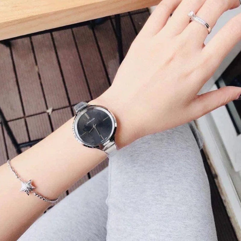 Women wearing Calvin Klein LIVELY watch with black dial and steel bracelet