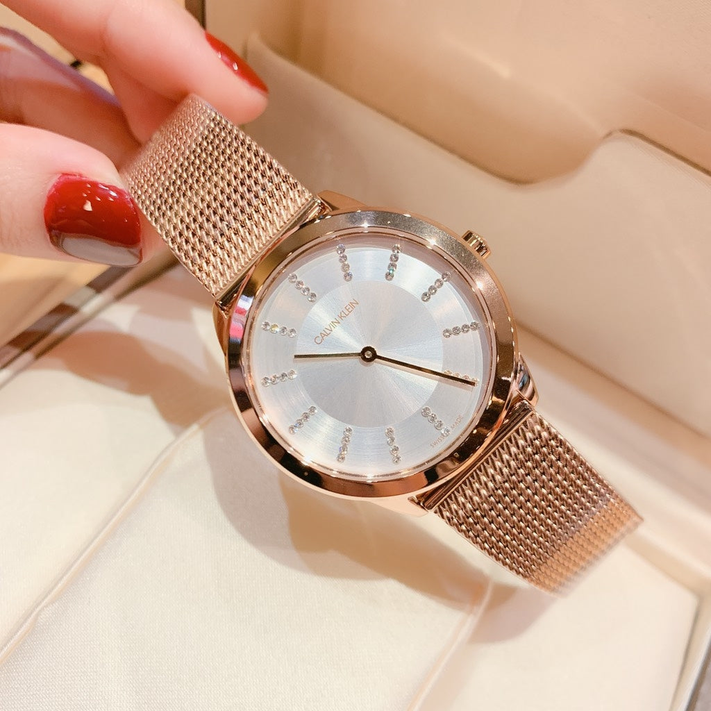 Calvin Klein Minimal women's watch worn on wrist with rose gold mesh strap and silver dial