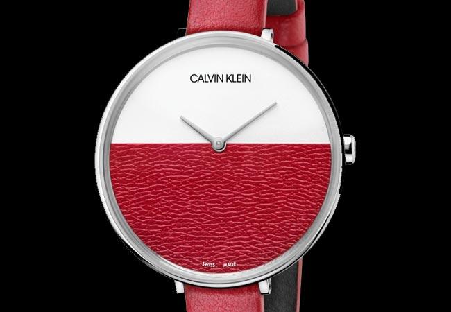 Detailed view of Calvin Klein Rise watch dial showing split white and textured red design