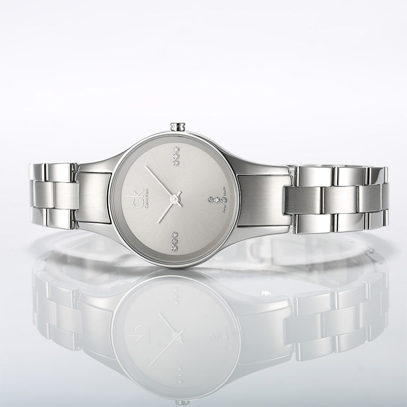 Calvin Klein Simplicity ladies watch displayed flat with reflection showing full bracelet