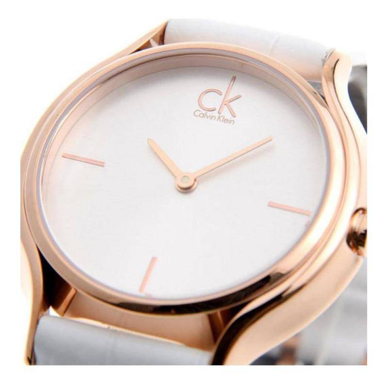 Close-up of white dial featuring Calvin Klein logo and rose gold hour indices
