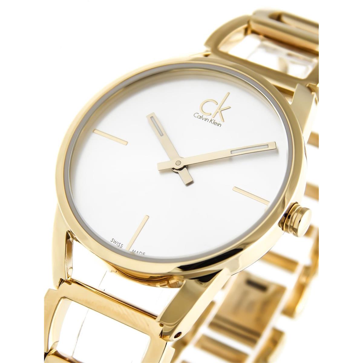 Calvin Klein Stately women's watch on wrist showing silver dial and gold steel strap