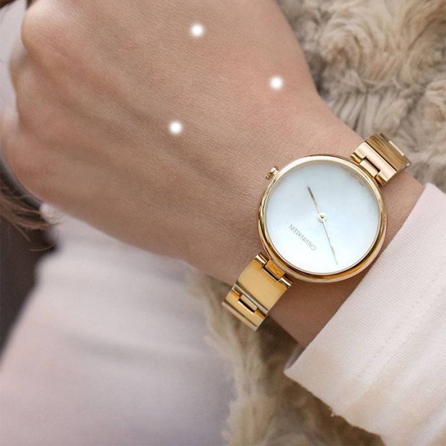 Calvin Klein Wavy gold watch on wrist showing silver dial and bracelet