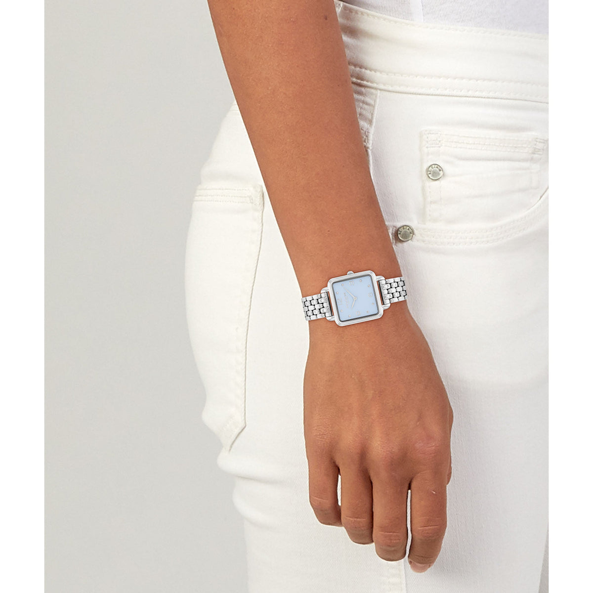 Coach light blue dial watch worn on wrist with stainless steel bracelet