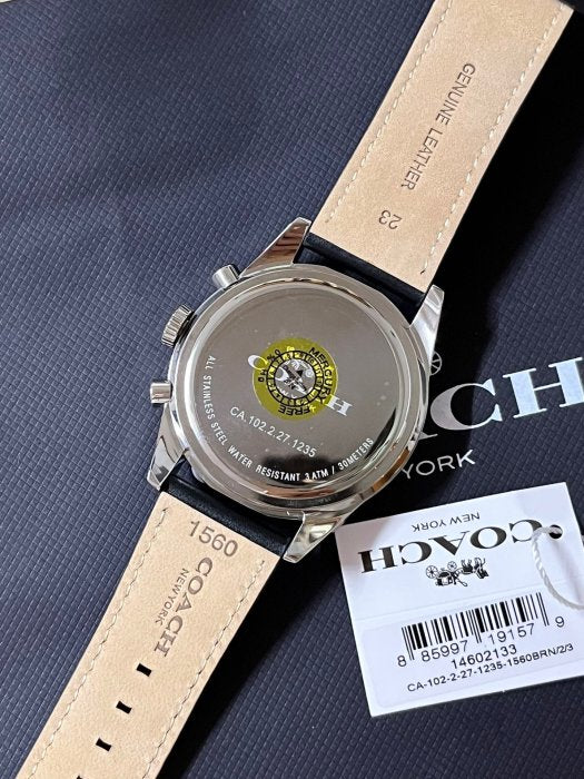Coach watch caseback with model and serial number, showing Coach branding and specifications