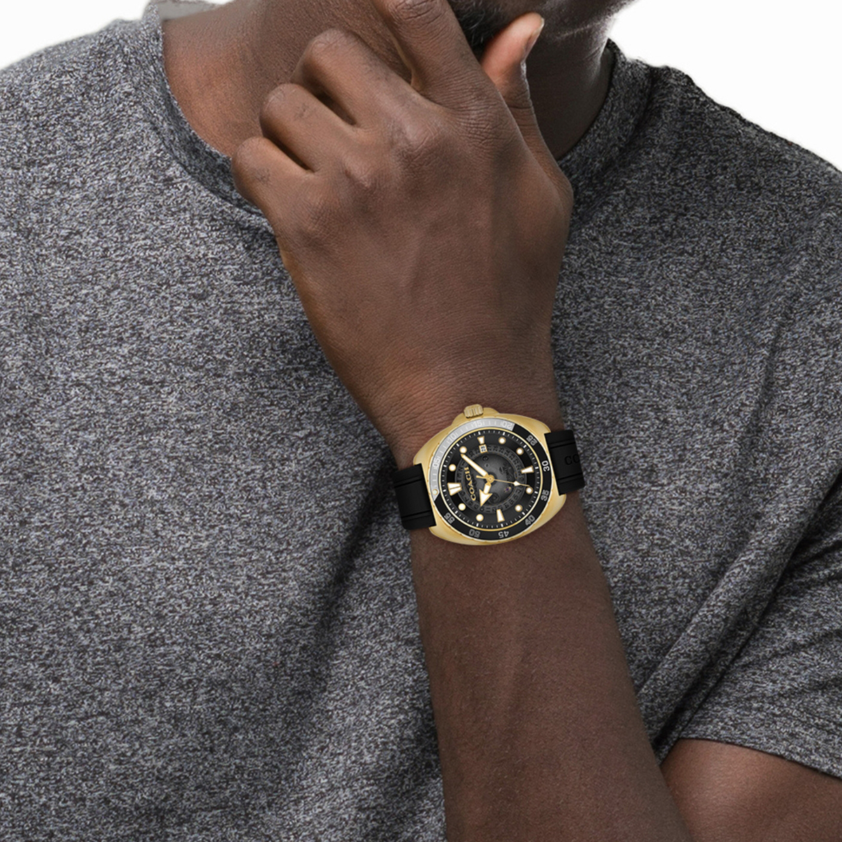 Coach Charter automatic watch on wrist showing gold-tone case and black dial detail