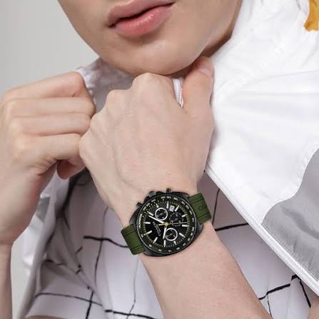 Coach chronograph watch worn on wrist displaying black dial with green strap