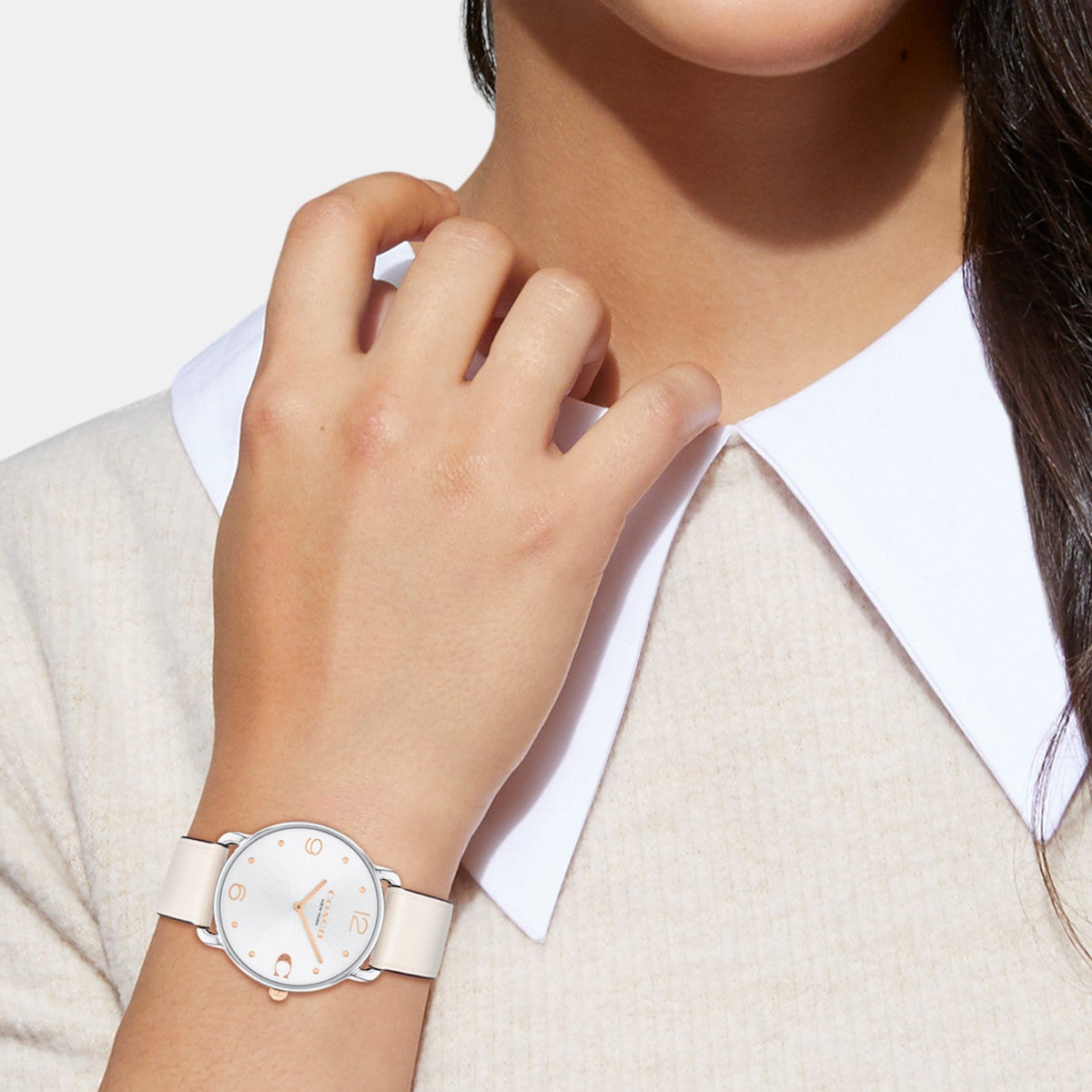 COACH Elliot women's watch worn on wrist with white dial and chalk leather strap