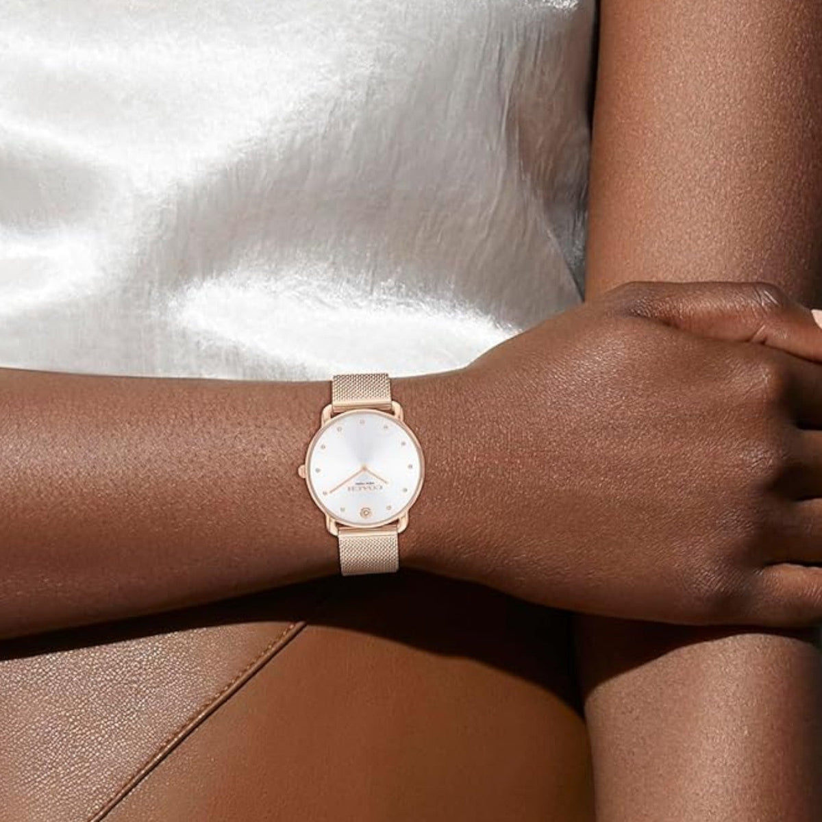 COACH Elliot rose gold watch worn on wrist with white sunray dial and mesh band
