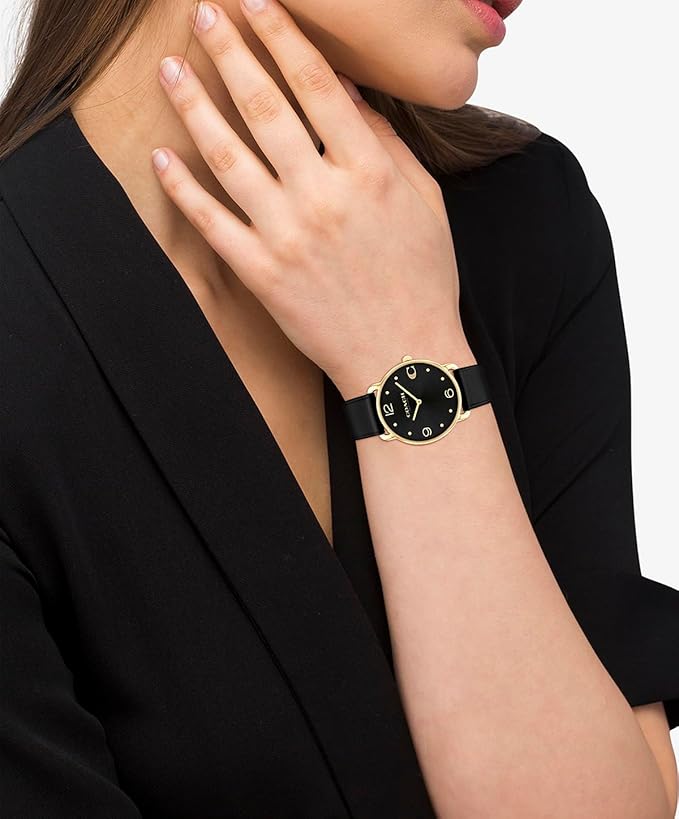 COACH Elliot women's watch worn on wrist with black dial and gold-tone case