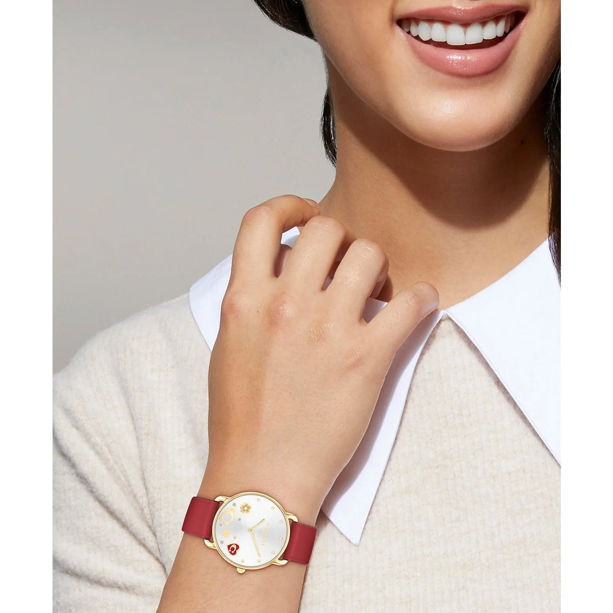 Coach Elliot watch worn on wrist, silver dial with gold-tone case and red leather strap
