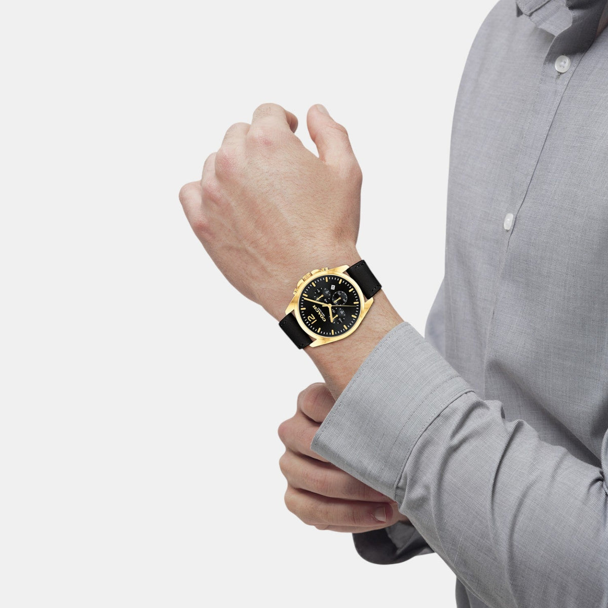 COACH Greyson men's chronograph watch worn on wrist with gold-tone case and black leather strap