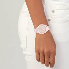 Coach Kitt blush ceramic watch worn on wrist with white outfit