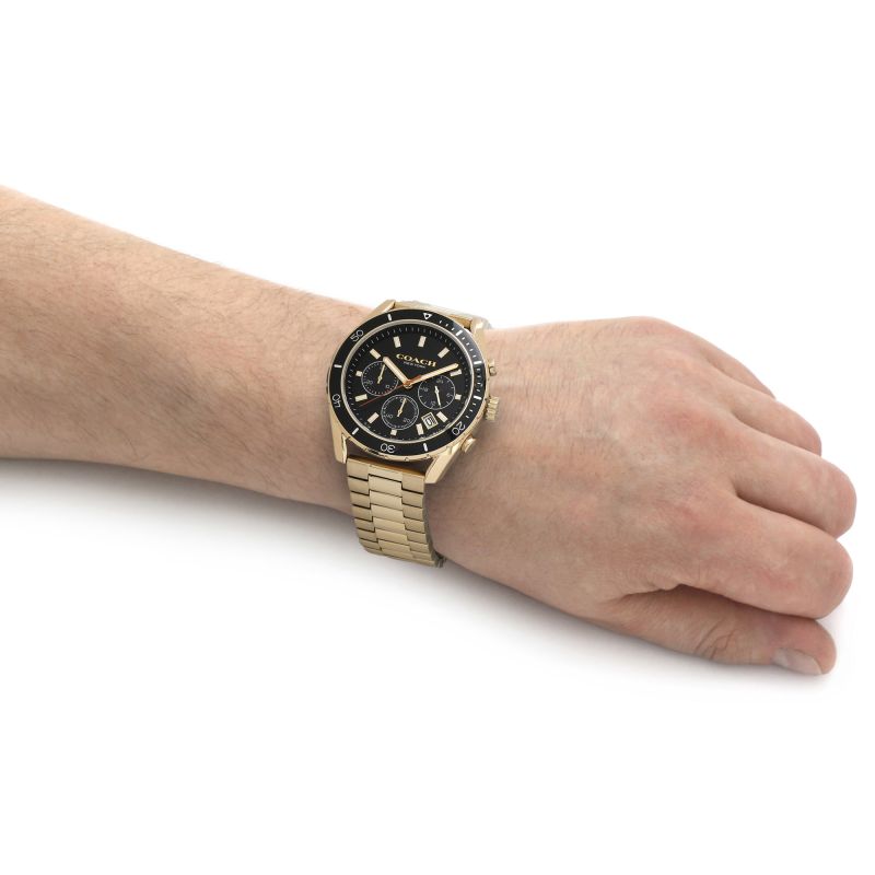 Coach Preston chronograph watch worn on wrist showing gold case, black dial, and gold-tone bracelet