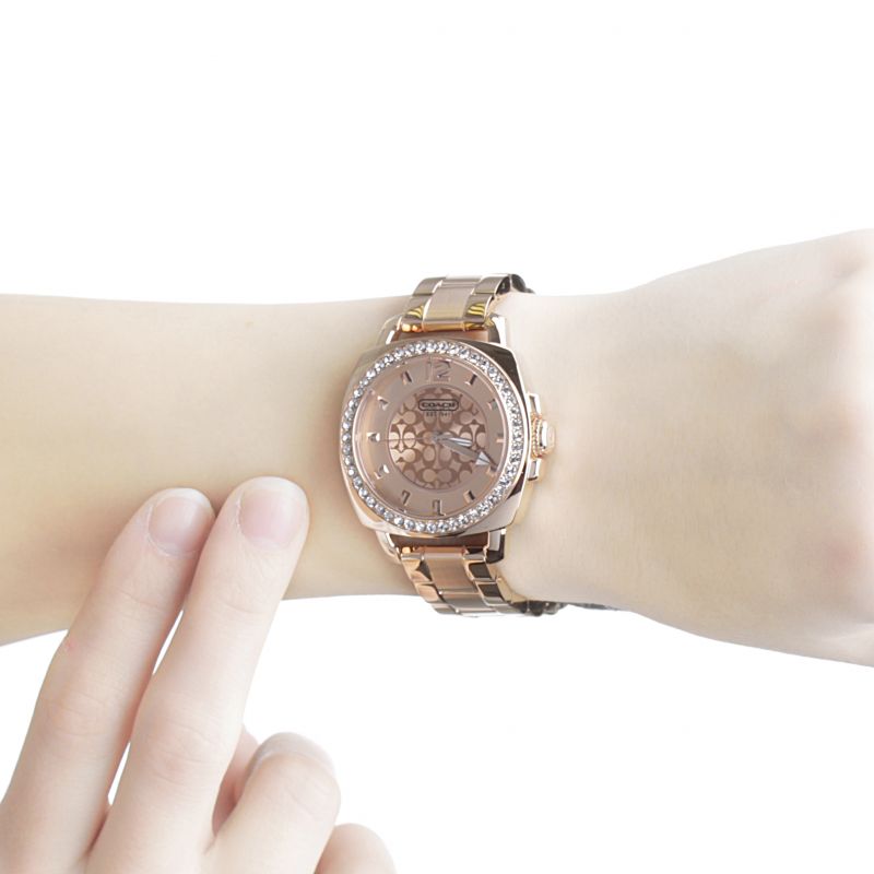 Coach rose gold watch on wrist showing dial and crystal bezel detail