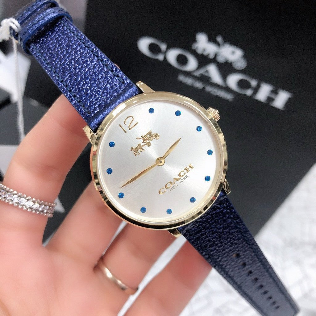 Coach Slim Easton watch worn on wrist showing gold case and navy leather strap