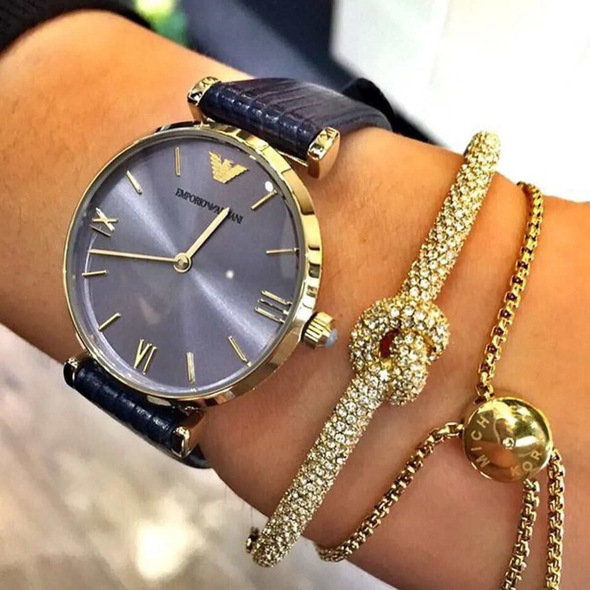 Emporio Armani AR1875 blue women's watch on wrist with gold-tone case and navy strap
