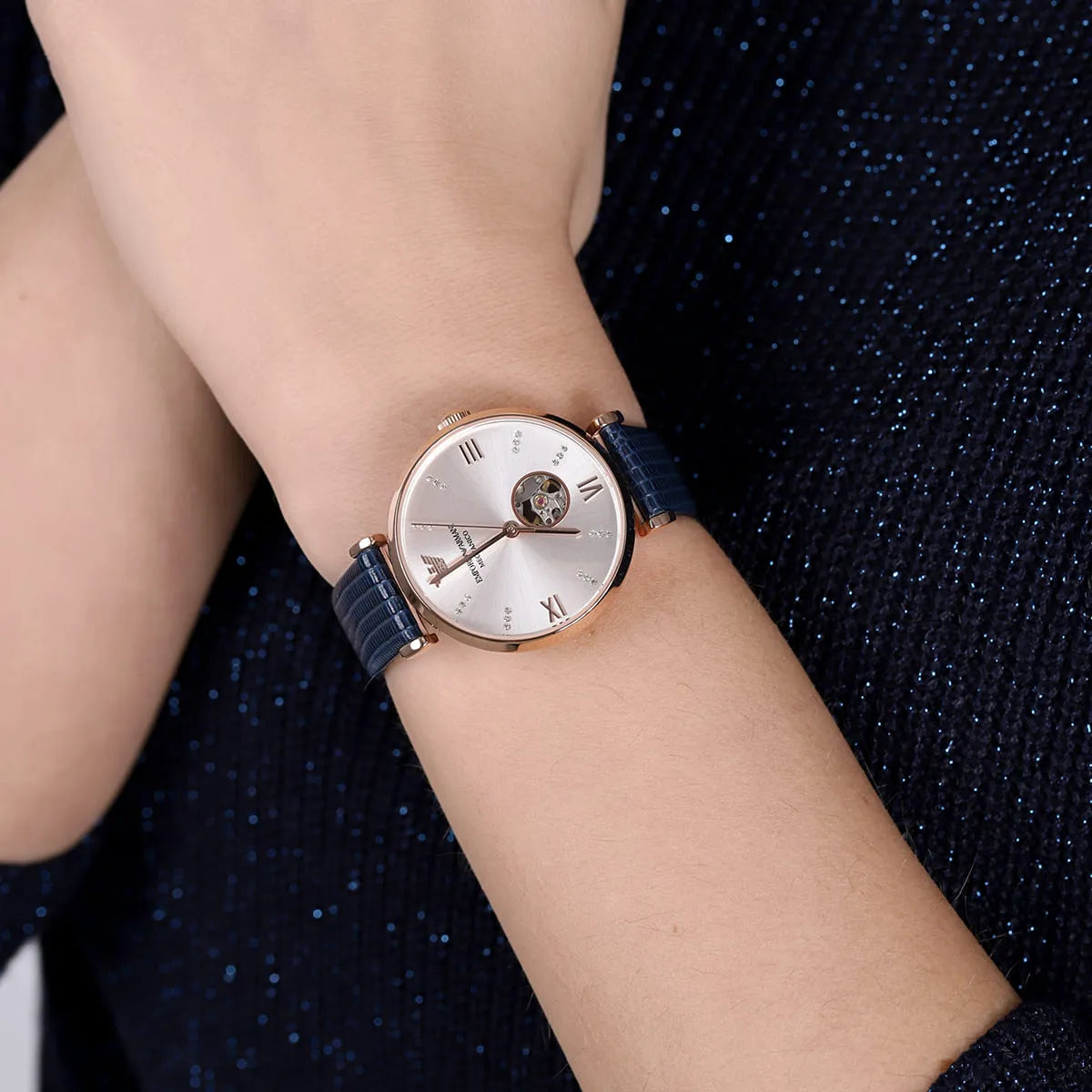 Emporio Armani Gianni rose gold mechanical women's watch on wrist with navy leather strap