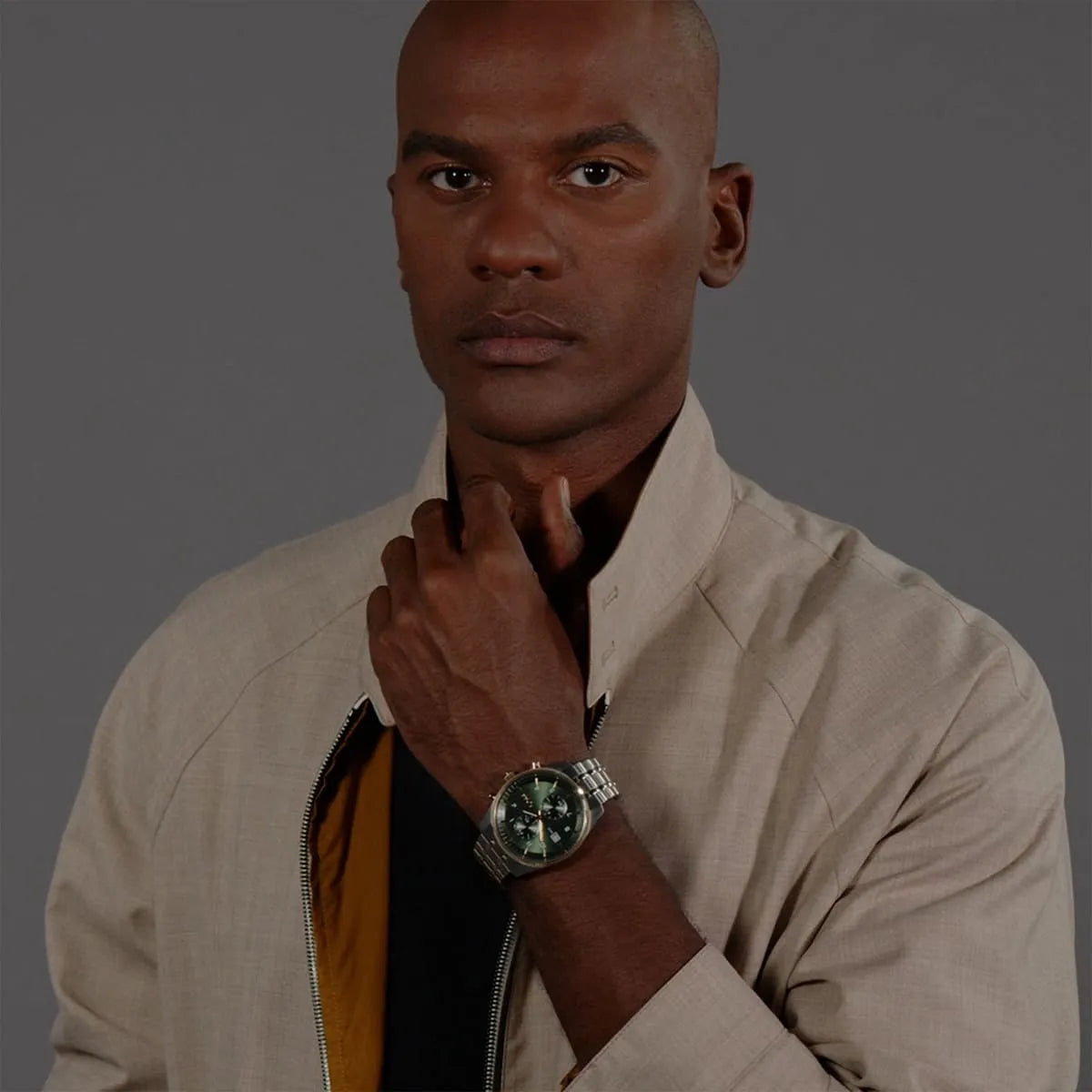 Man wearing Hugo Boss chronograph watch with green dial and stainless steel bracelet on wrist