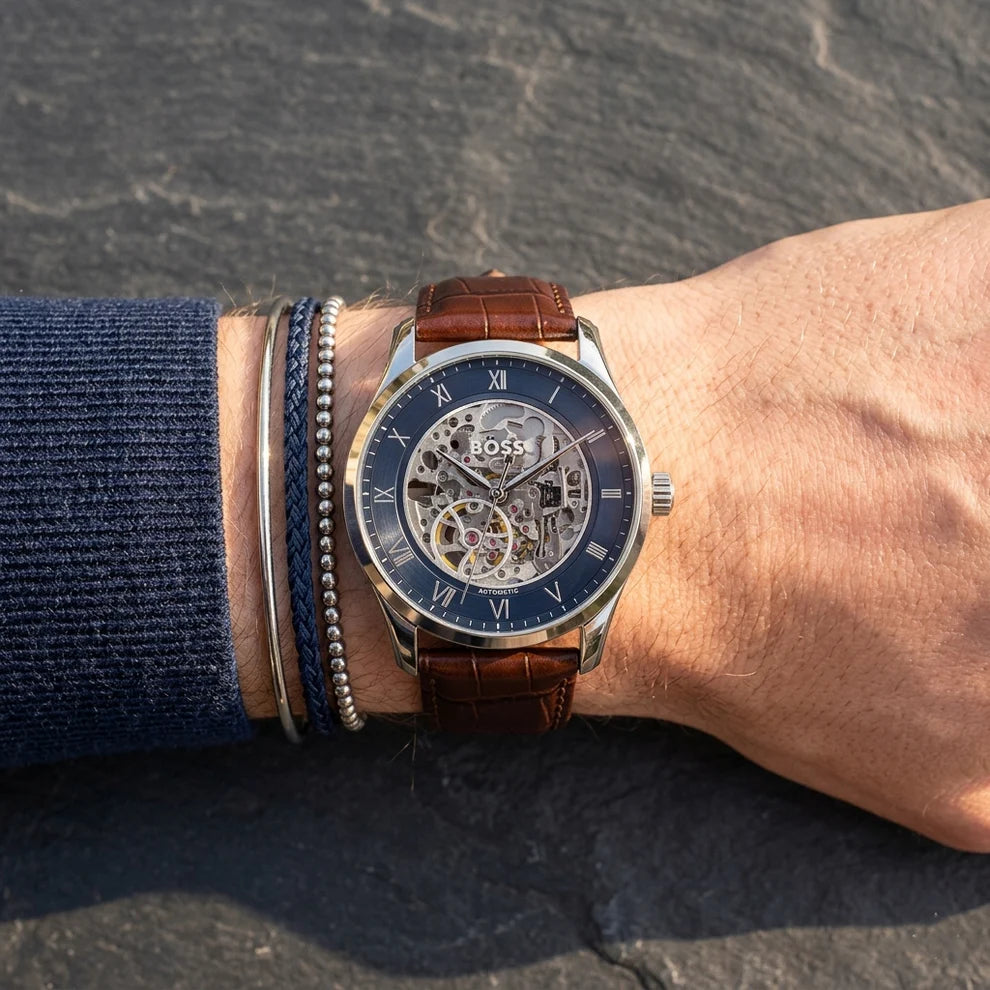 Hugo Boss skeleton watch on wrist showing navy dial with exposed automatic movement