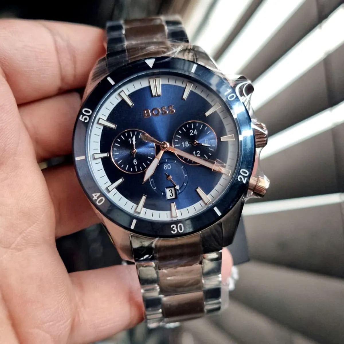 Hugo Boss Santiago chronograph watch held in hand with blue dial and subdials visible