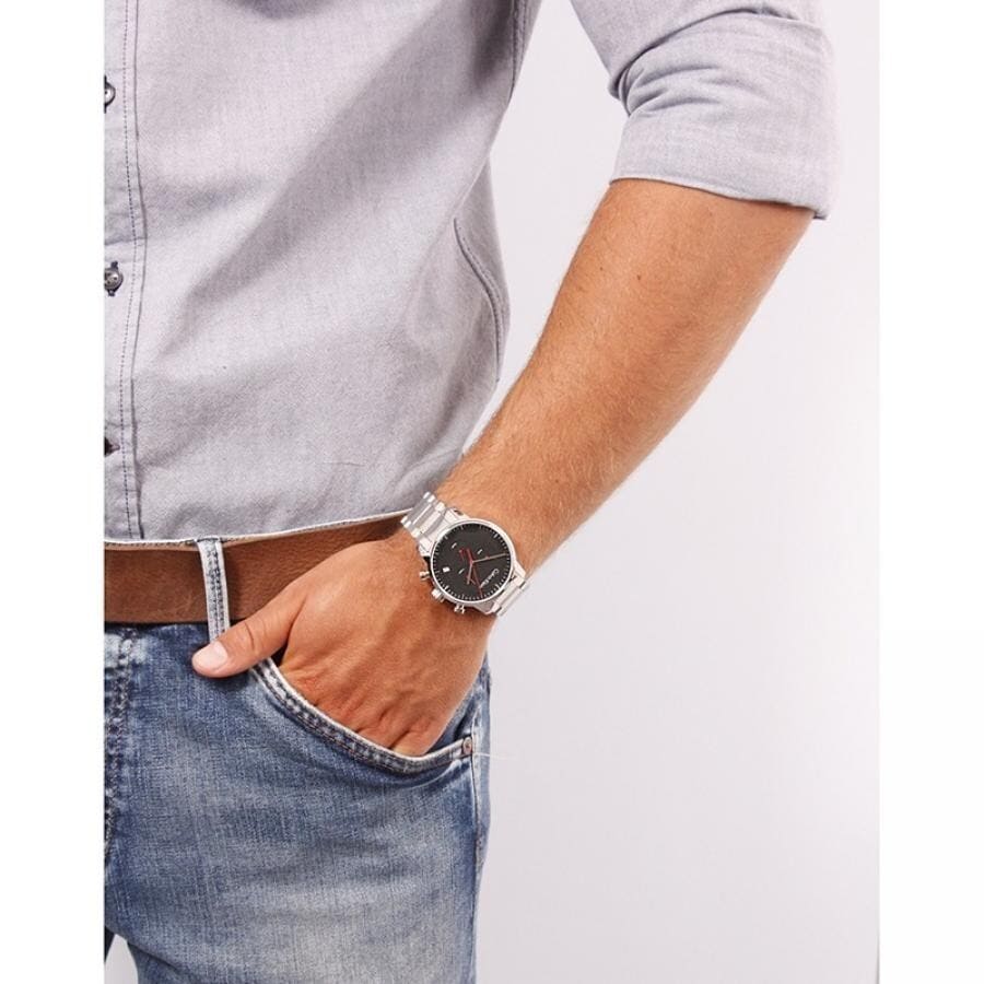 Calvin Klein men's chronograph watch on wrist with silver bracelet and black dial