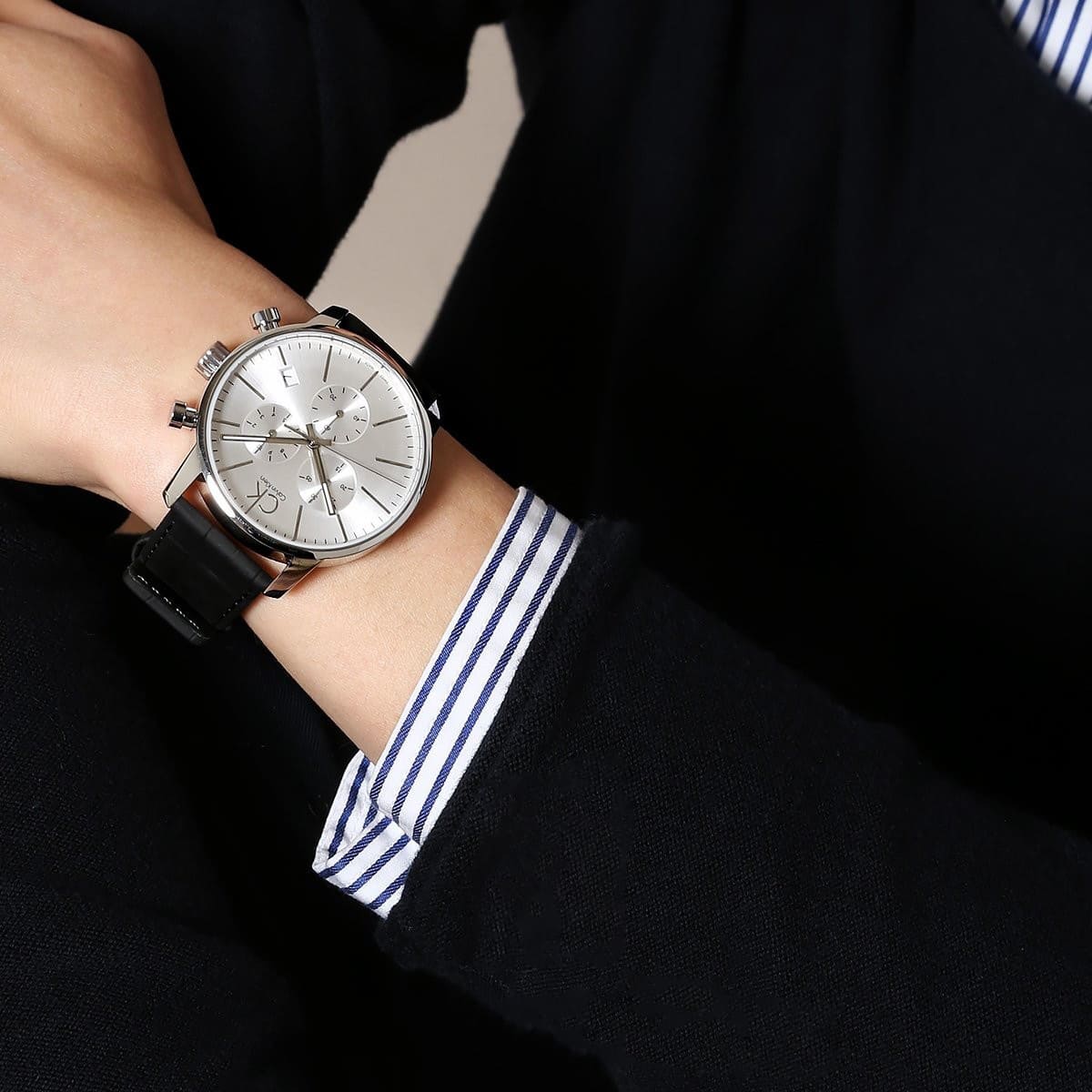 Calvin Klein City chronograph watch worn on wrist with silver dial and black strap