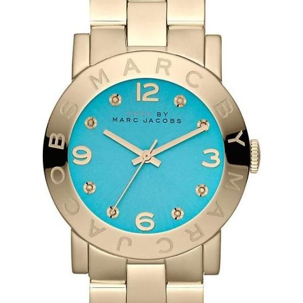 Close-up of turquoise blue dial with Arabic numerals, crystal indices, and Marc Jacobs branding