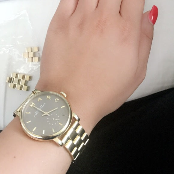 Marc By Marc Jacobs Baker MBM8631 women's watch worn on wrist with brown dial and gold bracelet